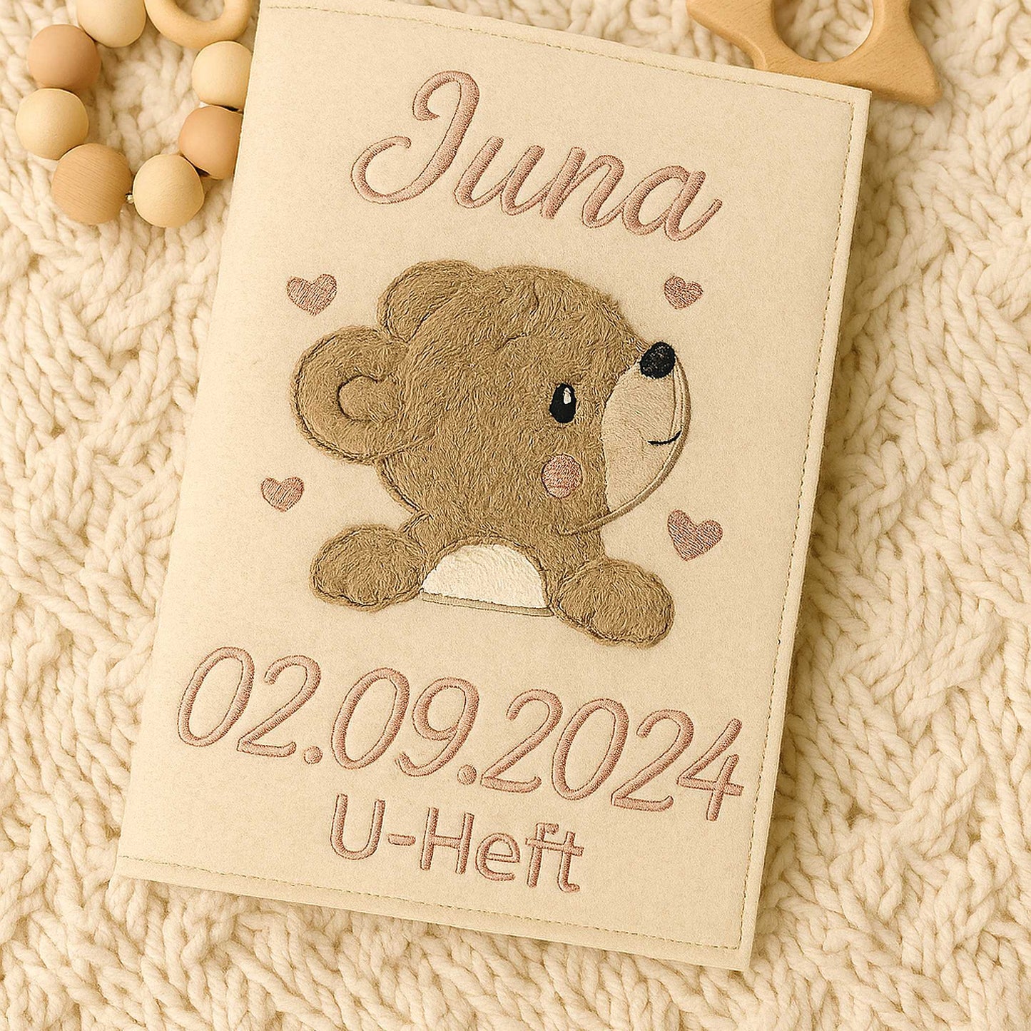 Bestickte H-Hefthülle personalisiert auf einer Wolldecke liegend