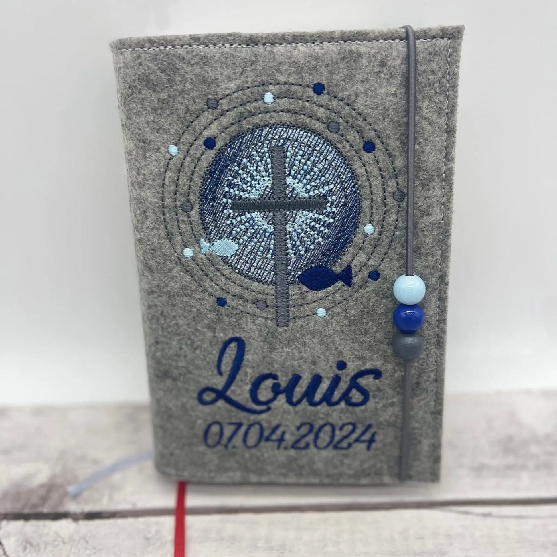 Gotteslobhülle Kreuz mit Schrein aus mittelgrauen Filz, Stickfarben blau mit Name und Datum der Erstkommunion