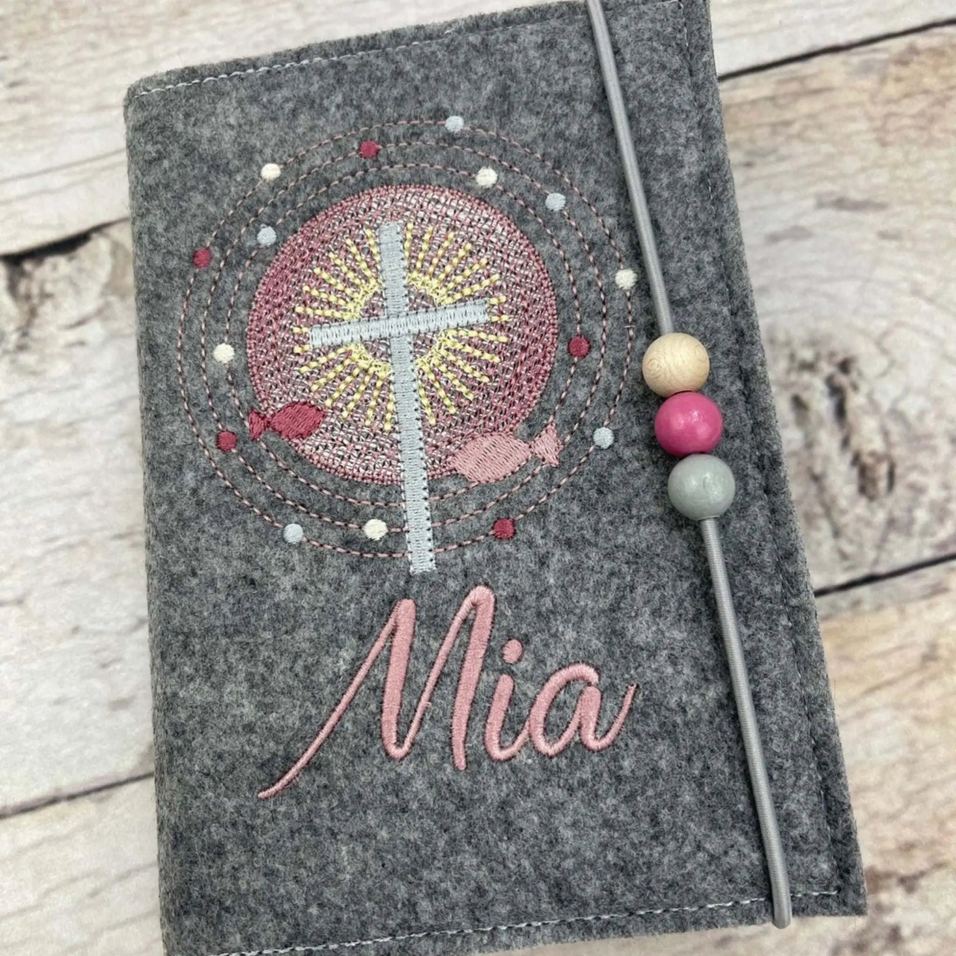 Gotteslobhülle Kreuz mit Schrein aus mittelgrauen Filz, Stickfarbe altrosa, mit Gummi und Perlen Detailansicht