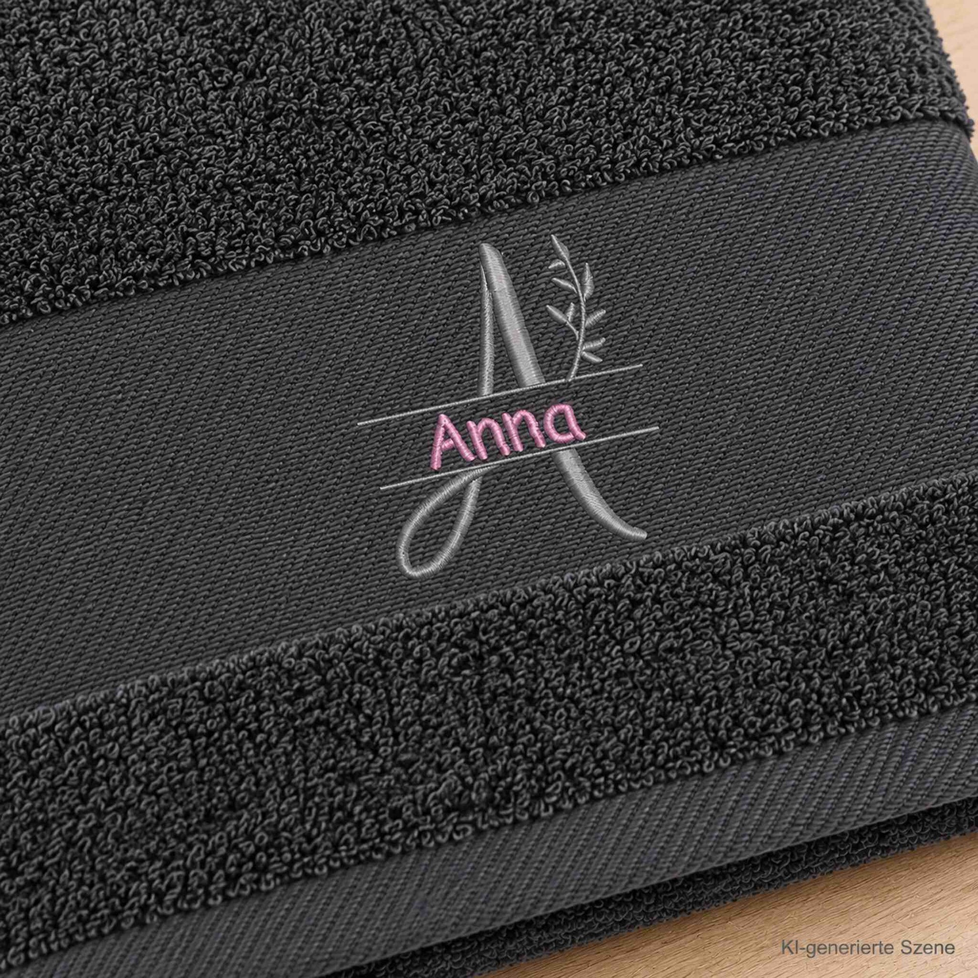 Detail der Stickerei auf anthrazitfarbenem Handtuch mit Monogramm A, Blattzweig und Name Anna
