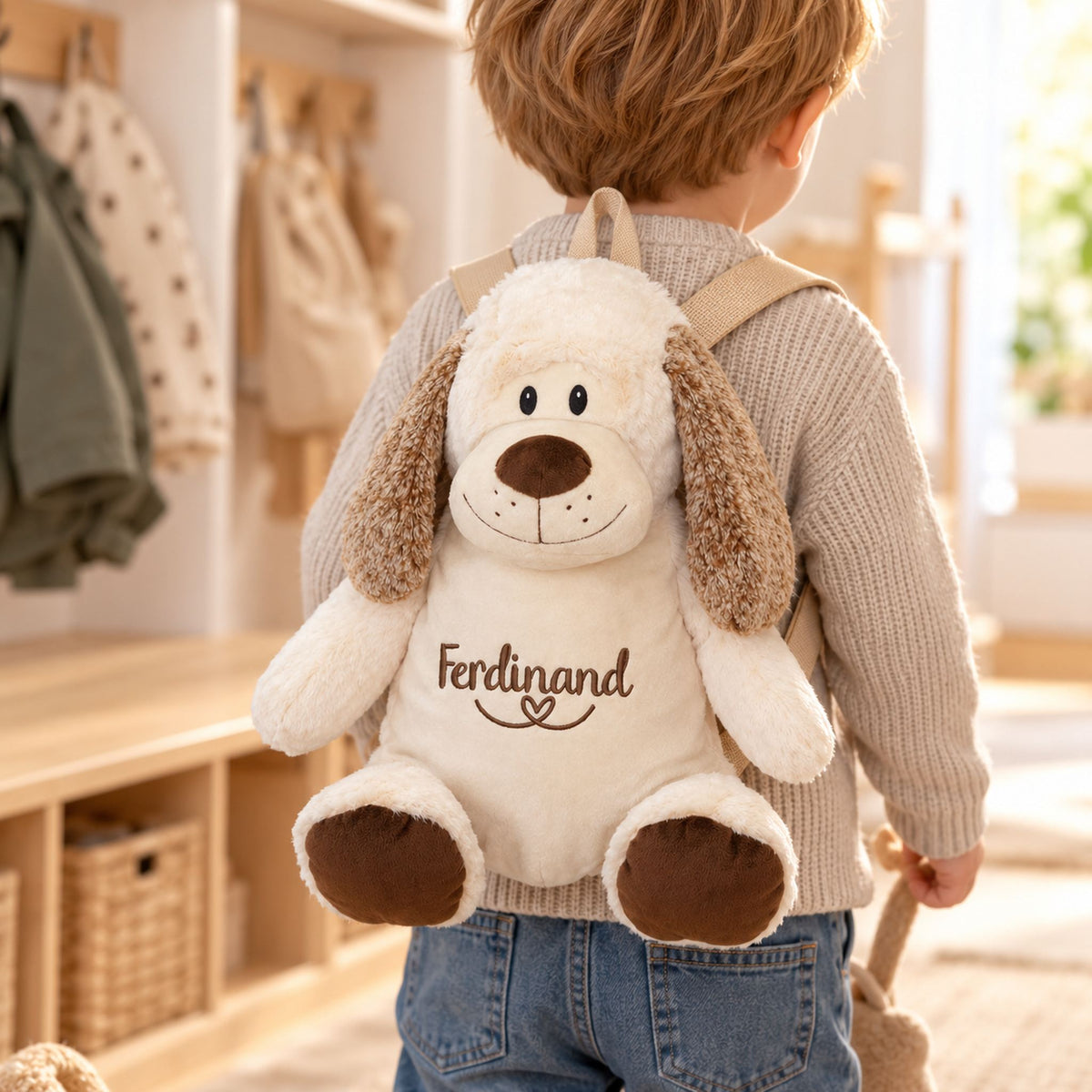 Kleines Kind trägt personalisierten Hund-Rucksack mit Name Ferdinand für Kindergarten und Kinderkrippe.