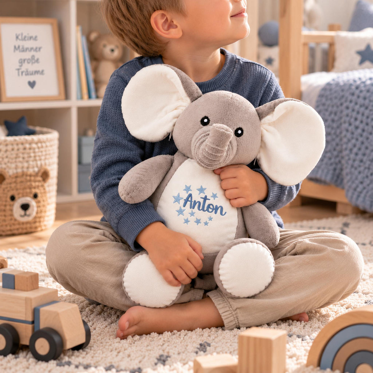 Junge hält ein personalisiertes Kuscheltier Elefant mit Name Anton und Sternen in den Händen